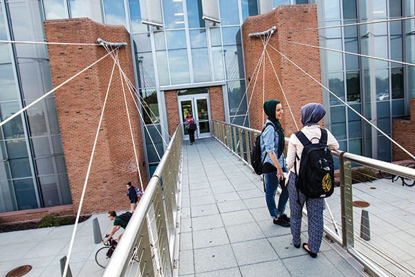 Students wearing hijabs on Science complex bridge
